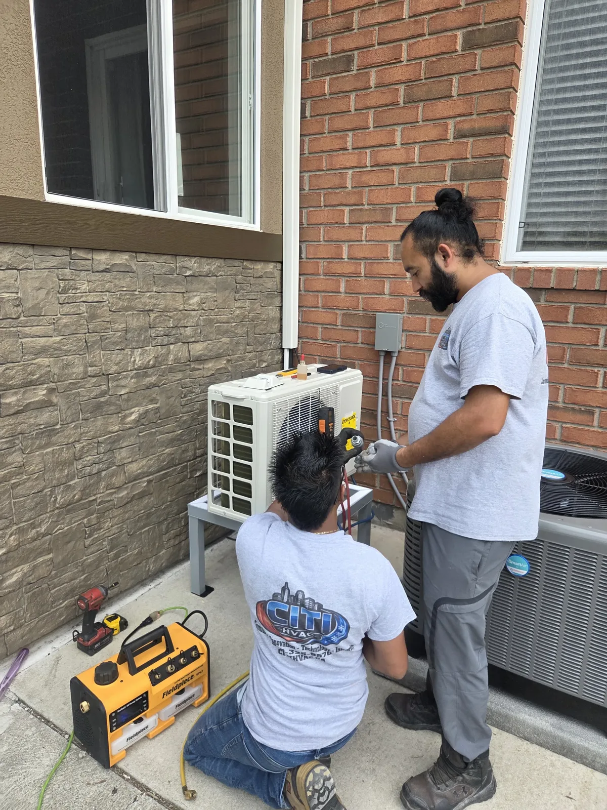 CITI HVAC technicians vacuuming and charging mini-split refrigerant lines — South Windsor ON