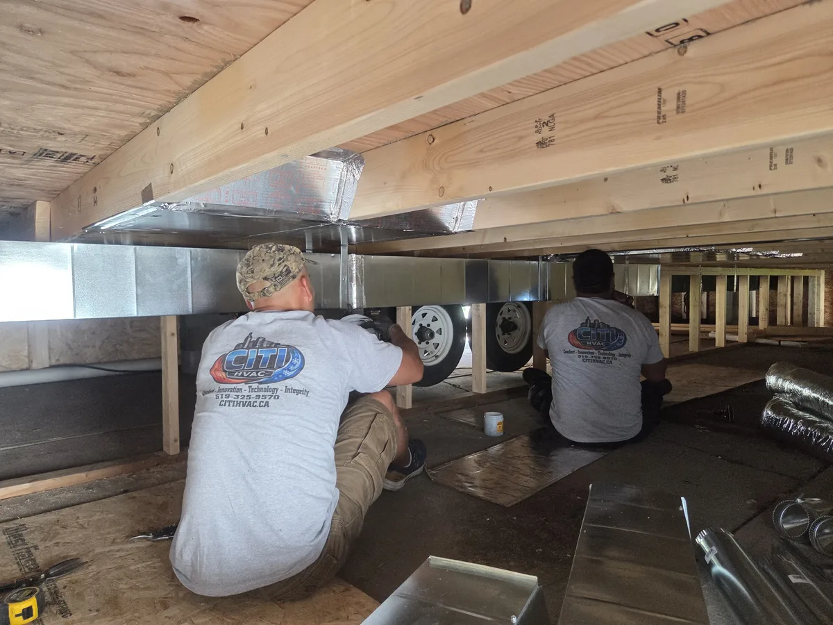 CITI HVAC team working under trailer — branded uniforms Chatham Ontario