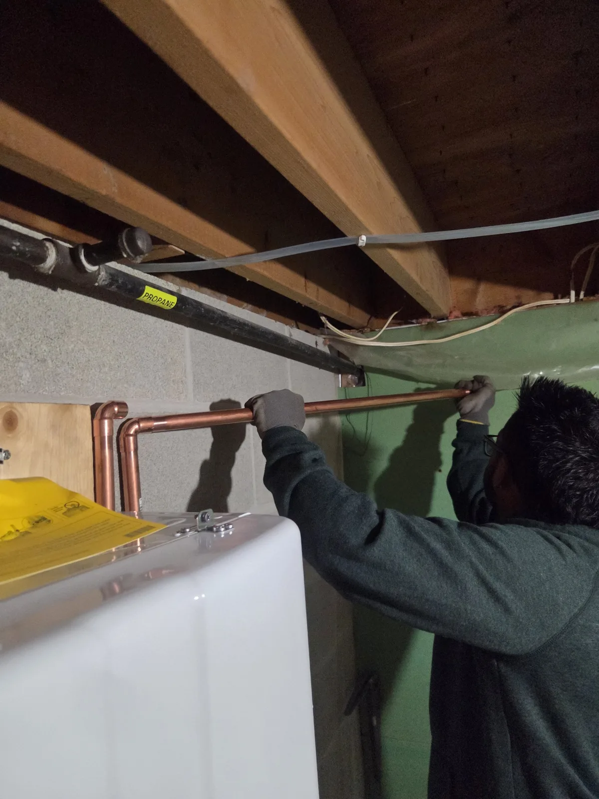 CITI HVAC technician running copper water line at a tankless water heater