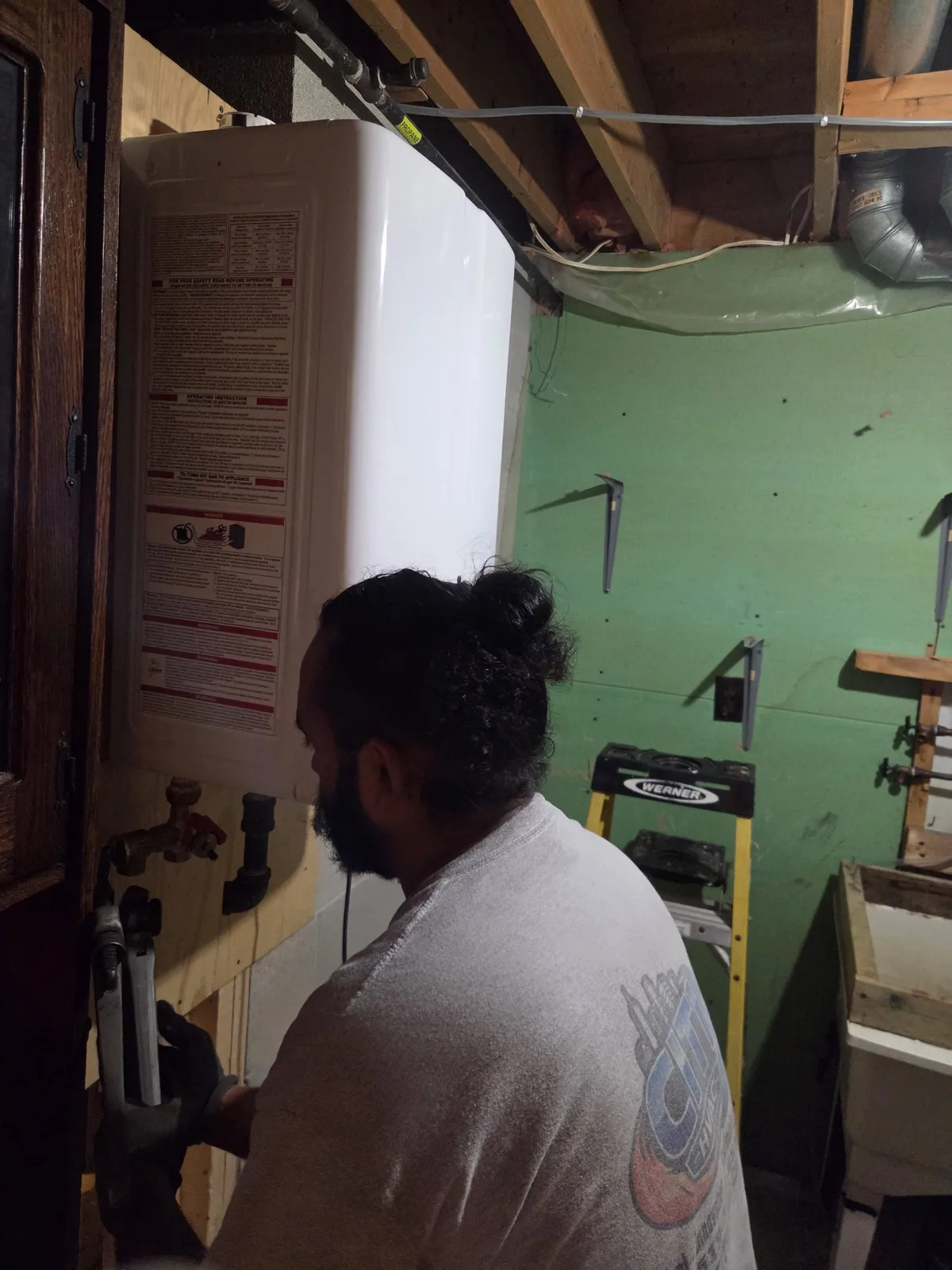CITI HVAC technician completing gas and water connections on a tankless water heater
