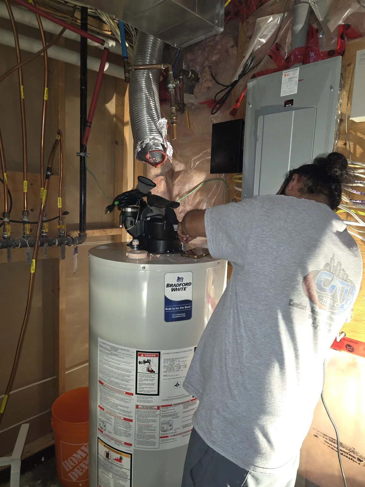 CITI HVAC technician installing power vent blower on a gas tank water heater