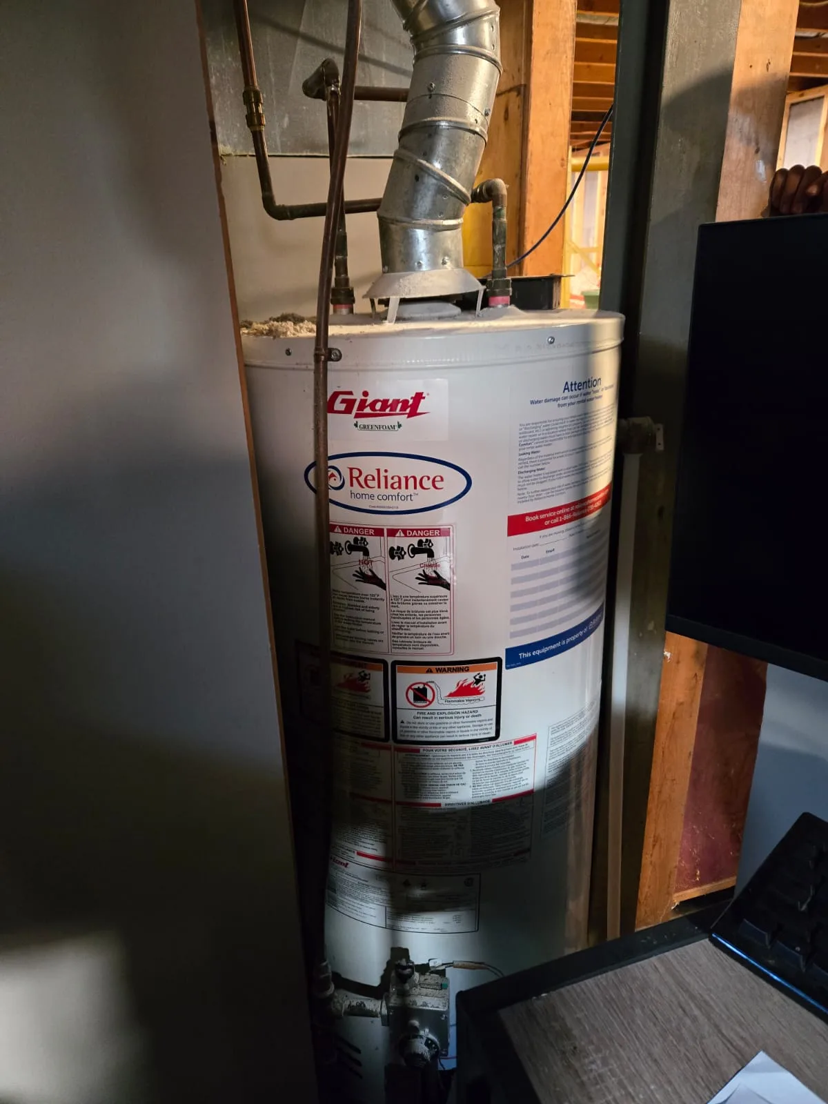 Old conventional-vent (CV) gas tank water heater before conversion to a tankless unit