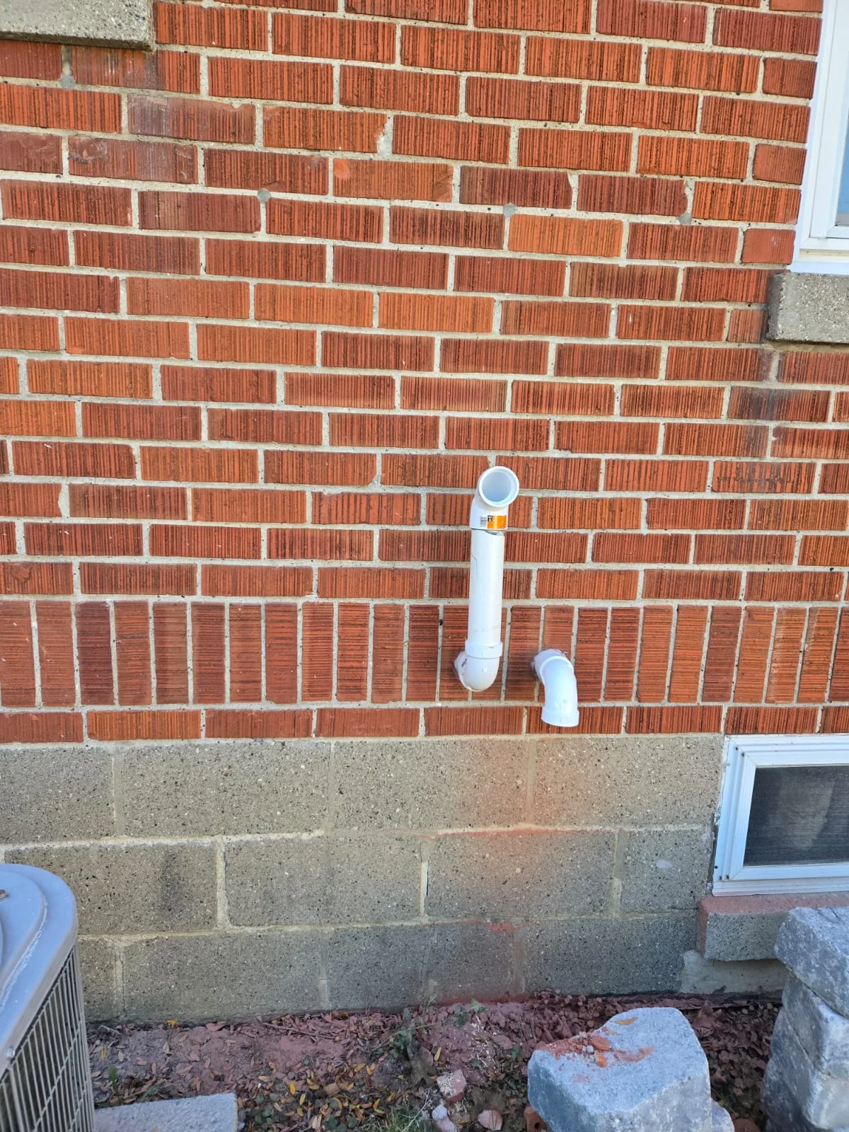 PVC intake and exhaust vent terminations through a brick wall for a power-vented tankless water heater