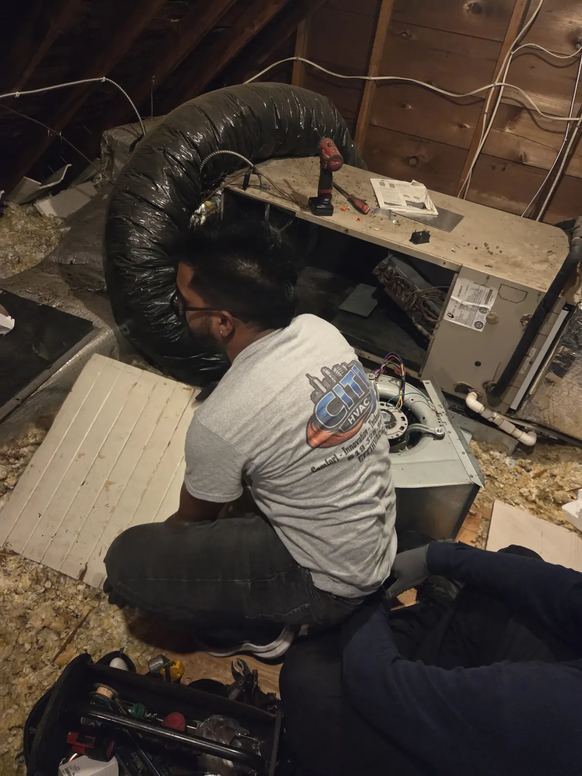 CITI HVAC technician assessing air handler unit in attic — South Windsor ON